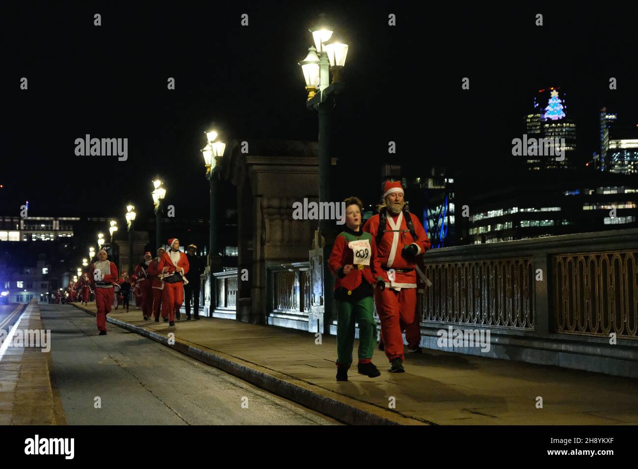 Londra, Regno Unito, 2 dicembre 2021, centinaia di escursionisti, Gli utenti in sedia a rotelle e i corridori hanno partecipato all'evento festivo 'Santa in the City' 5K. I partecipanti che hanno donato Santa Suits e Beards hanno seguito un percorso intorno alla Southbank e alla City di Londra - alcuni erano in squadre in esecuzione per il Maggies Centre, la Royal Marsden Cancer Charity, Single Homeless Project e molte altre cause. Credit: Undicesima ora Fotografia/Alamy Live News Foto Stock