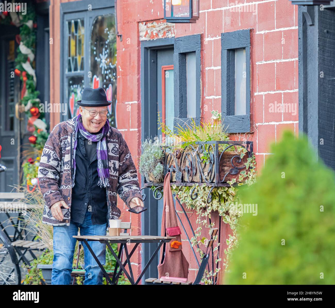 Uomo anziano felice godendo il suo coffe alla caffetteria all'aperto. Uomo anziano e alla moda che si rilassa al caffè e si fa un caffè. Foto Stock