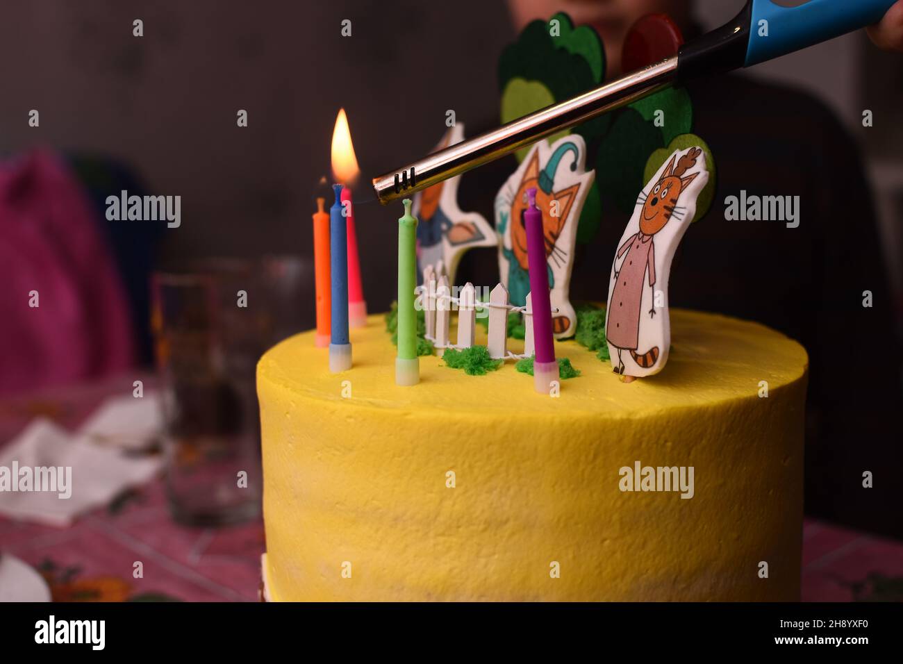 accendendo le candele su una torta con un accendino. Foto Stock