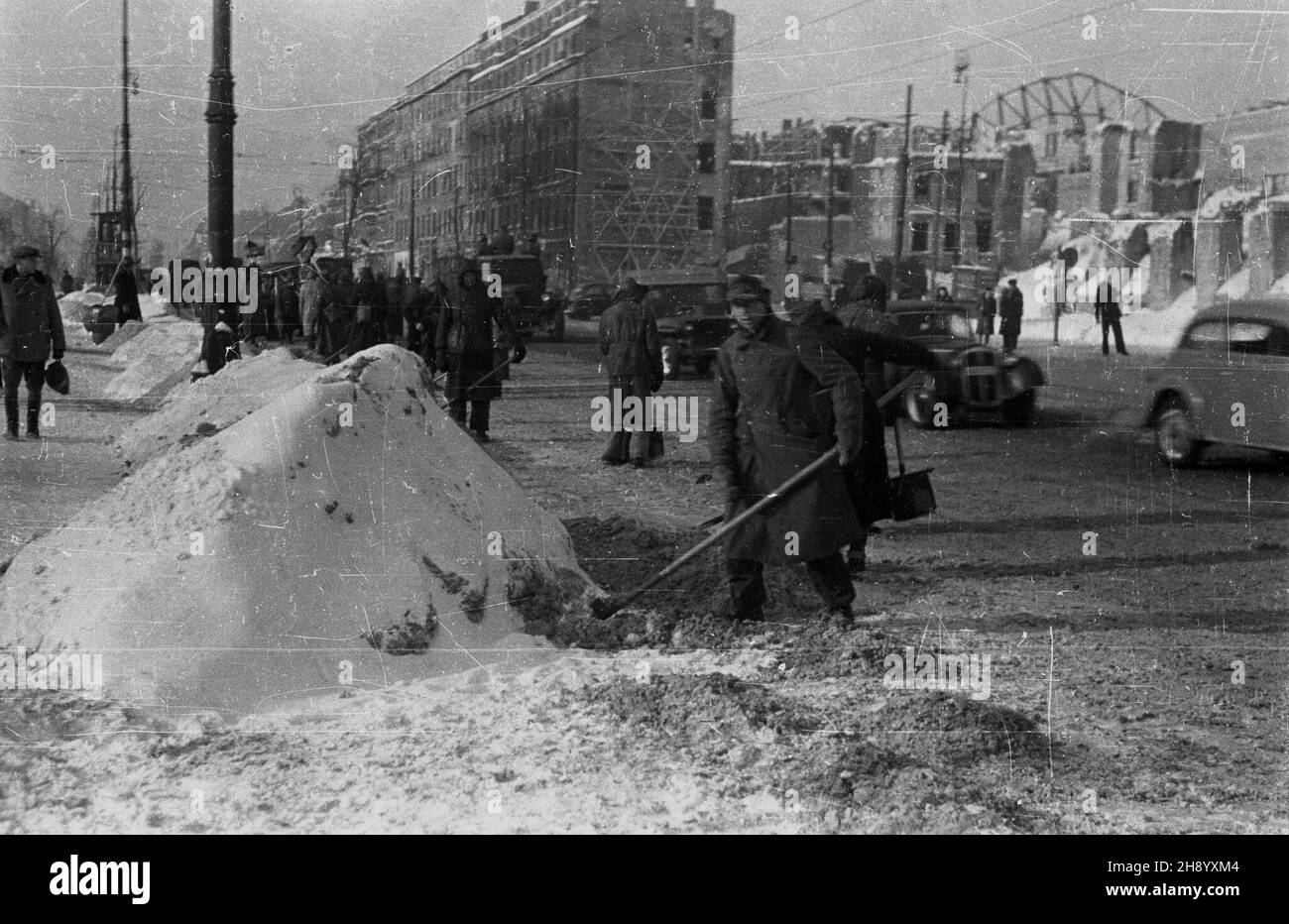 Warszawa, 1946-12. Silne opady œniegu spowodowa³y, ¿e wiele warszawskich ulic by³o nieprzejezdnych. Oprócz s³u¿b oczyszczania miasta ulice odœnie¿ali równie¿ niemieccy jeñcy wojenni. NZ. Robotnicy oczyszczaj¹ Aleje Jerozolimskie. Ad PAP/Stanis³aw D¹browiecki Dok³adny dzieñ wydarzenia nieustalony. Varsavia, 1946 dicembre. Le pesanti nevicate hanno reso impraticabili molte strade di Varsavia. Oltre ai servizi di pulizia della città, i prigionieri di guerra tedeschi stavano liberando la neve dalle strade. Nella foto: Sgombero della neve su Nowy Swiat Street. Ad PAP/Stanislaw Dabrowiecki Foto Stock