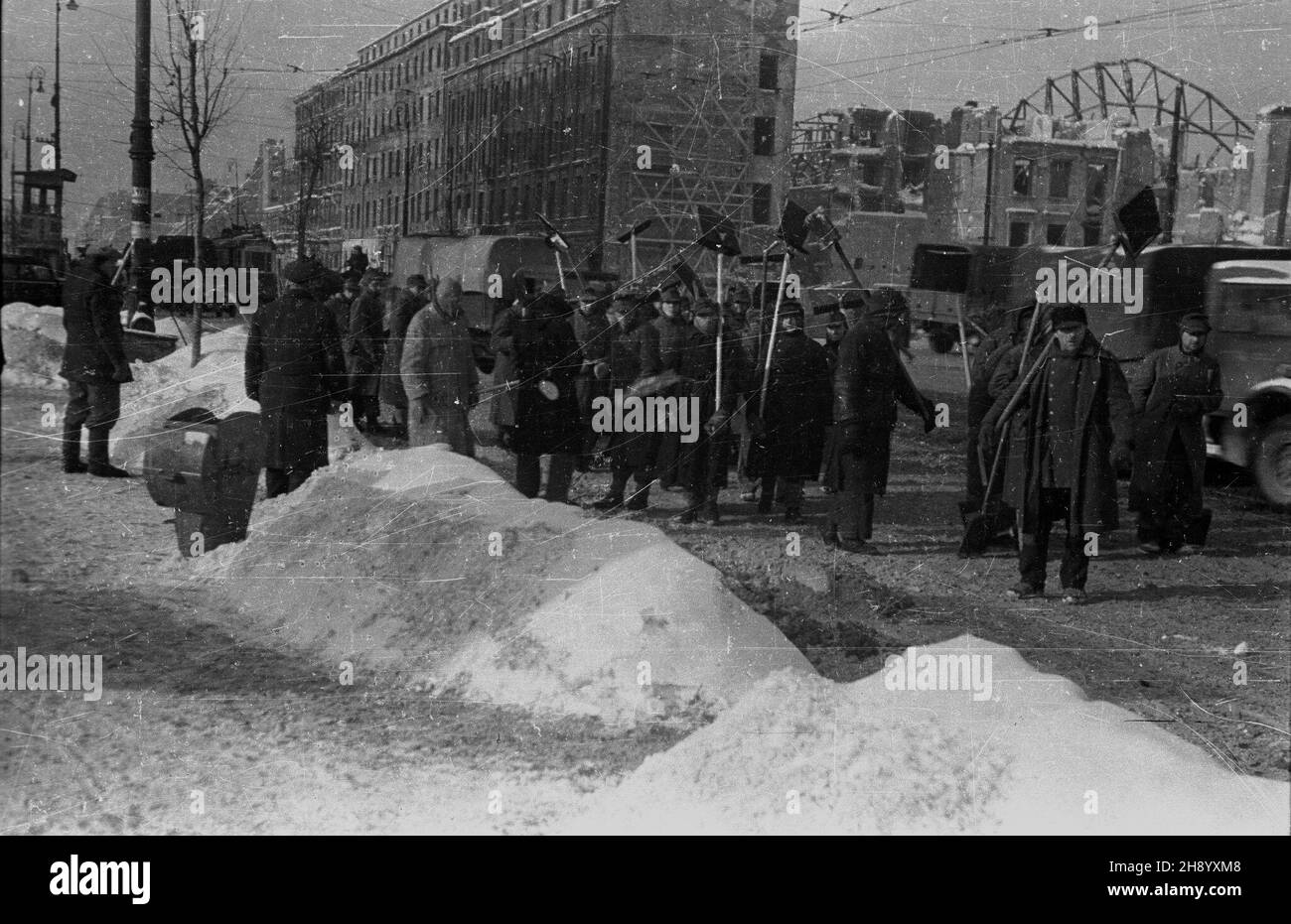 Warszawa, 1946-12. Silne opady œniegu spowodowa³y, ¿e wiele warszawskich ulic by³o nieprzejezdnych. Oprócz s³u¿b oczyszczania miasta ulice odœnie¿ali równie¿ niemieccy jeñcy wojenni. Robotnicy oczyszczaj¹ Aleje Jerozolimskie ze œniegu. Ad PAP/Stanis³aw D¹browiecki Dok³adny dzieñ wydarzenia nieustalony. Varsavia, 1946 dicembre. Le pesanti nevicate hanno reso impraticabili molte strade di Varsavia. Oltre ai servizi di pulizia della città, i prigionieri di guerra tedeschi stavano liberando la neve dalle strade. Nella foto: Sgombero della neve su Nowy Swiat Street. Ad PAP/Stanislaw Dabrowiecki Foto Stock