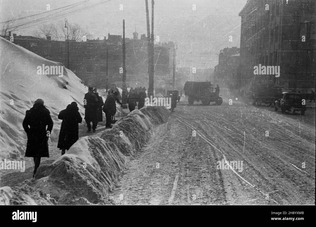 Warszawa, 1946-12. Silne opady œniegu spowodowa³y, ¿e wiele warszawskich ulic by³o nieprzejezdnych. Oprócz s³u¿b oczyszczania miasta ulice odœnie¿ali równie¿ niemieccy jeñcy wojenni. NZ. Skrzy¿owanie ul. Nowy Œwiat z Alejami Jerozolimskimi; w tle plac Trzech Krzy¿y. ad PAP/Stanis³aw D¹browiecki Dok³adny dzieñ wydarzenia nieustalony. Varsavia, 1946 dicembre. Le pesanti nevicate hanno reso impraticabili molte strade di Varsavia. Oltre ai servizi di pulizia della città, i prigionieri di guerra tedeschi stavano liberando la neve dalle strade. Nella foto: L'intersezione di via Nowy Swiat con via Jerozolimskie, nel backgro Foto Stock