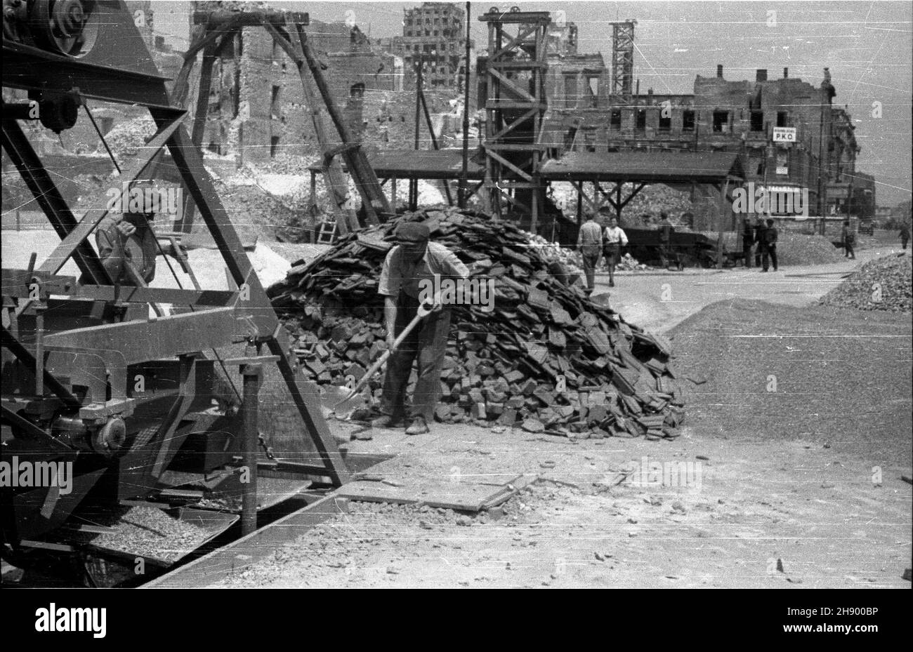 Warszawa, 1947, wiosna. Porz¹dkowanie gruzowiska w Œródmieœciu. NZ. Maszyna do mielenia gruzu. W tle zrujnowany budynek na rogu ulicy Marsza³kowskiej i Sienkiewicza. bb/pp PAP Varsavia, primavera 1947. Rimozione delle macerie nel centro di Varsavia; sullo sfondo: Rovine di un edificio all'incrocio di Marszalkowska e Sienkiewicza. Nella figura: Macchina frantumatrice di macerie. bb/pp PAP Foto Stock