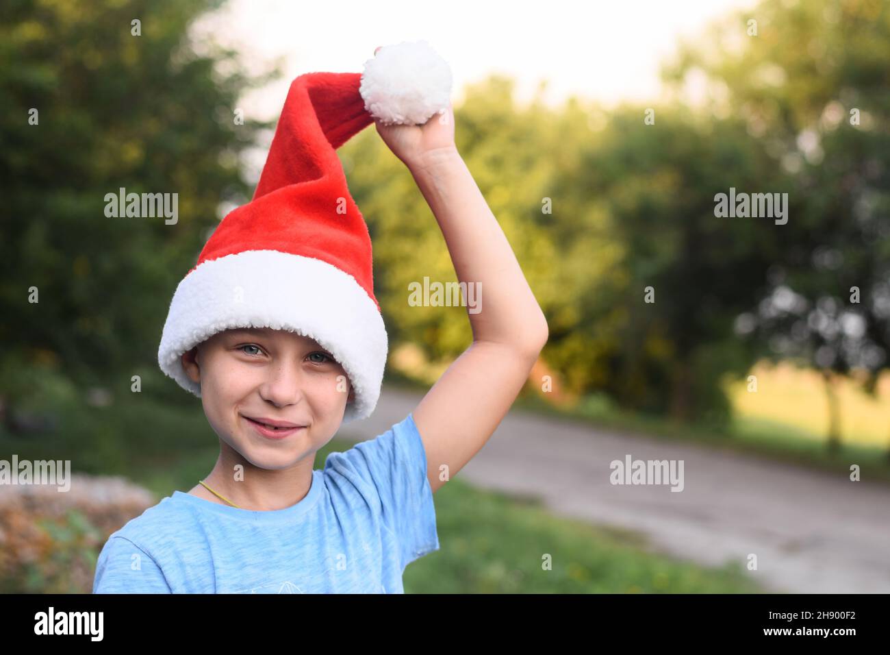 Un ragazzo sorridente nel cappello dell'aiutante di Babbo Natale. Foto Stock