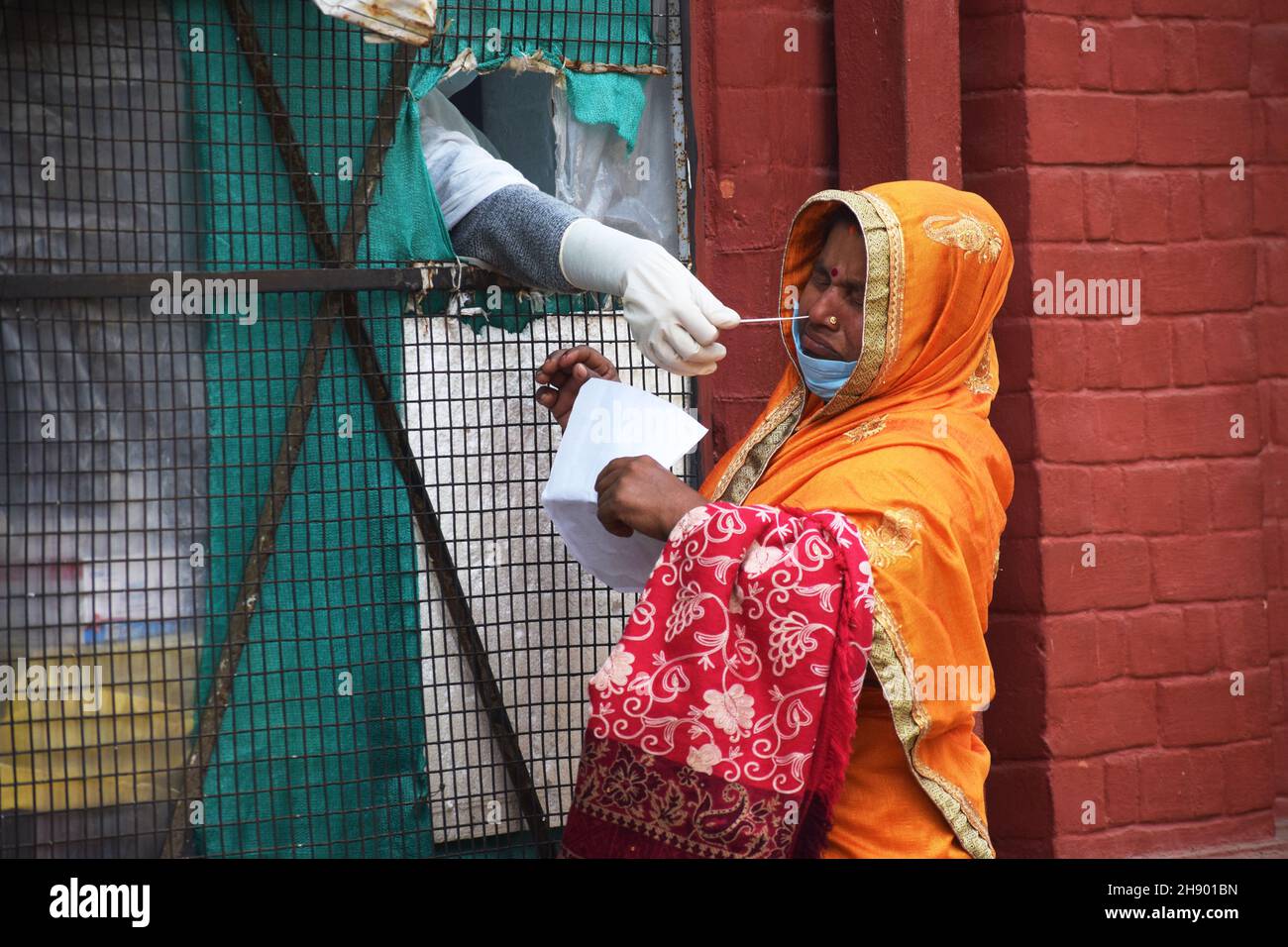 Prayagraj. 2 Dic 2021. Un operatore sanitario prende un campione di tampone nasale da una donna per testare con Rapid Antigen Test (RAT) per COVID-19 nel distretto di Prayagraj, nello stato settentrionale dell'India di Uttar Pradesh, 2 dicembre 2021. Il COVID-19 dell'India è aumentato a 34,606,541 il giovedì, mentre 9,765 nuovi casi sono stati registrati durante le ultime 24 ore attraverso il paese, i dati più recenti del Ministero federale della sanità hanno indicato. Credit: Str/Xinhua/Alamy Live News Foto Stock