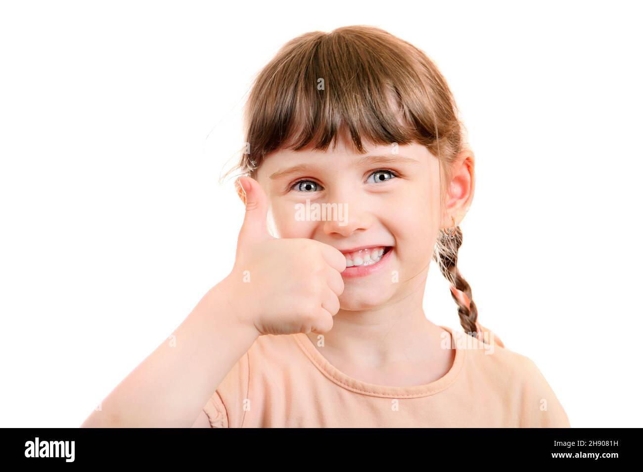 Ragazza piccola allegra con Thumb Up Gesture isolato sullo sfondo bianco Foto Stock