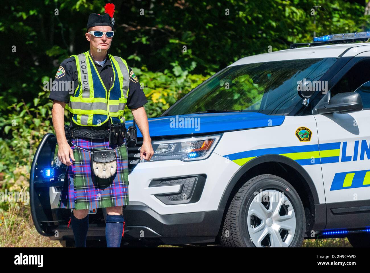 Lincoln, New Hampshire, Stati Uniti d'America – 17 settembre 2016. Ufficiale di polizia che indossa un chilt scozzese, da una macchina di pattuglia a Lincoln, NH. Foto Stock