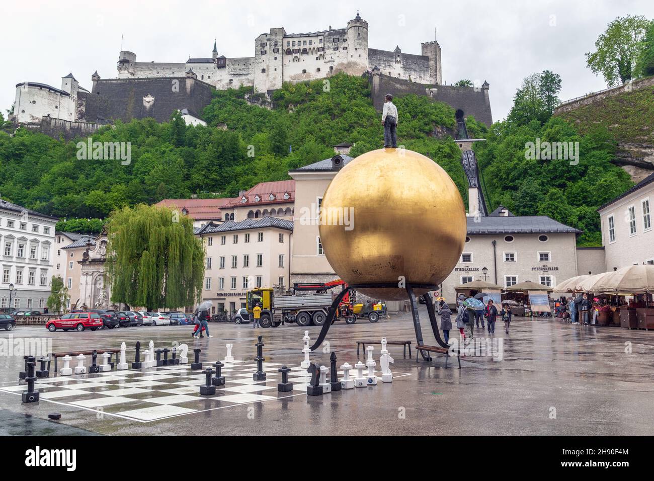 SALISBURGO, AUSTRIA - 20 MAGGIO 2019: Piazza Сathedral con un monumento insolito a uno chef di pasticceria su una mongolfiera e una vista sul castello di Hohensalzburg Foto Stock