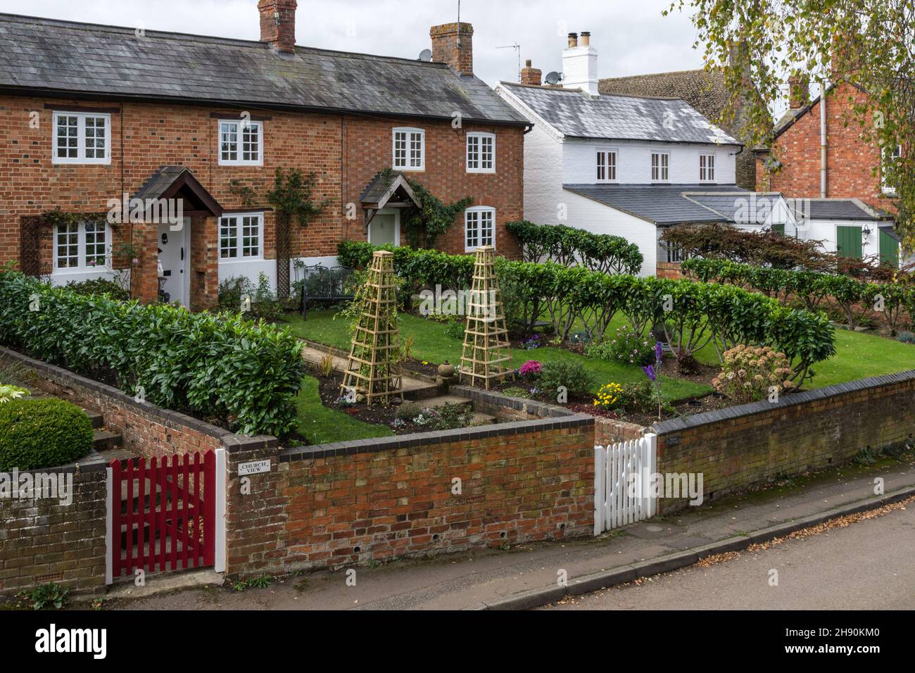 Fila di cottage terrazzati con lunghi giardini nel villaggio di Abthorpe, Northamptonshire, Regno Unito Foto Stock