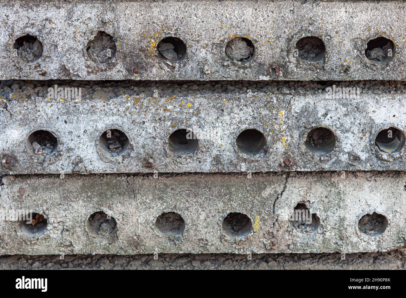 Solette in calcestruzzo con vuoti rotondi. Elemento di costruzione residenziale. Materiali da costruzione in una pila Foto Stock