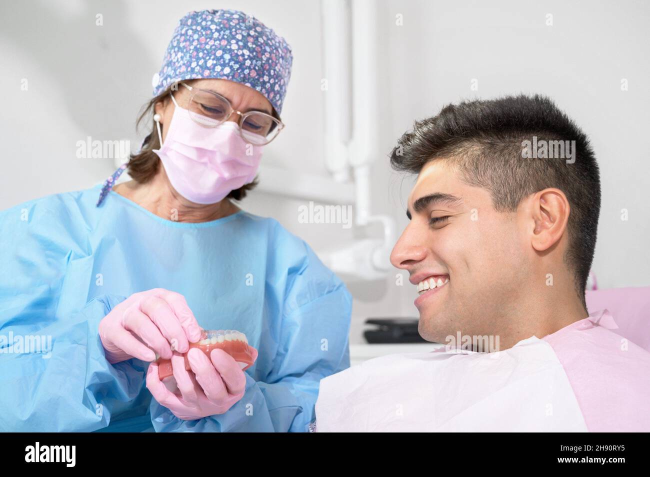 Supporto ortodontista invisibile per l'allineamento dei denti. In clinica mostra i dispositivi di allineamento in plastica trasparente rimuovibili dal paziente o l'uso invisalign e. Foto Stock