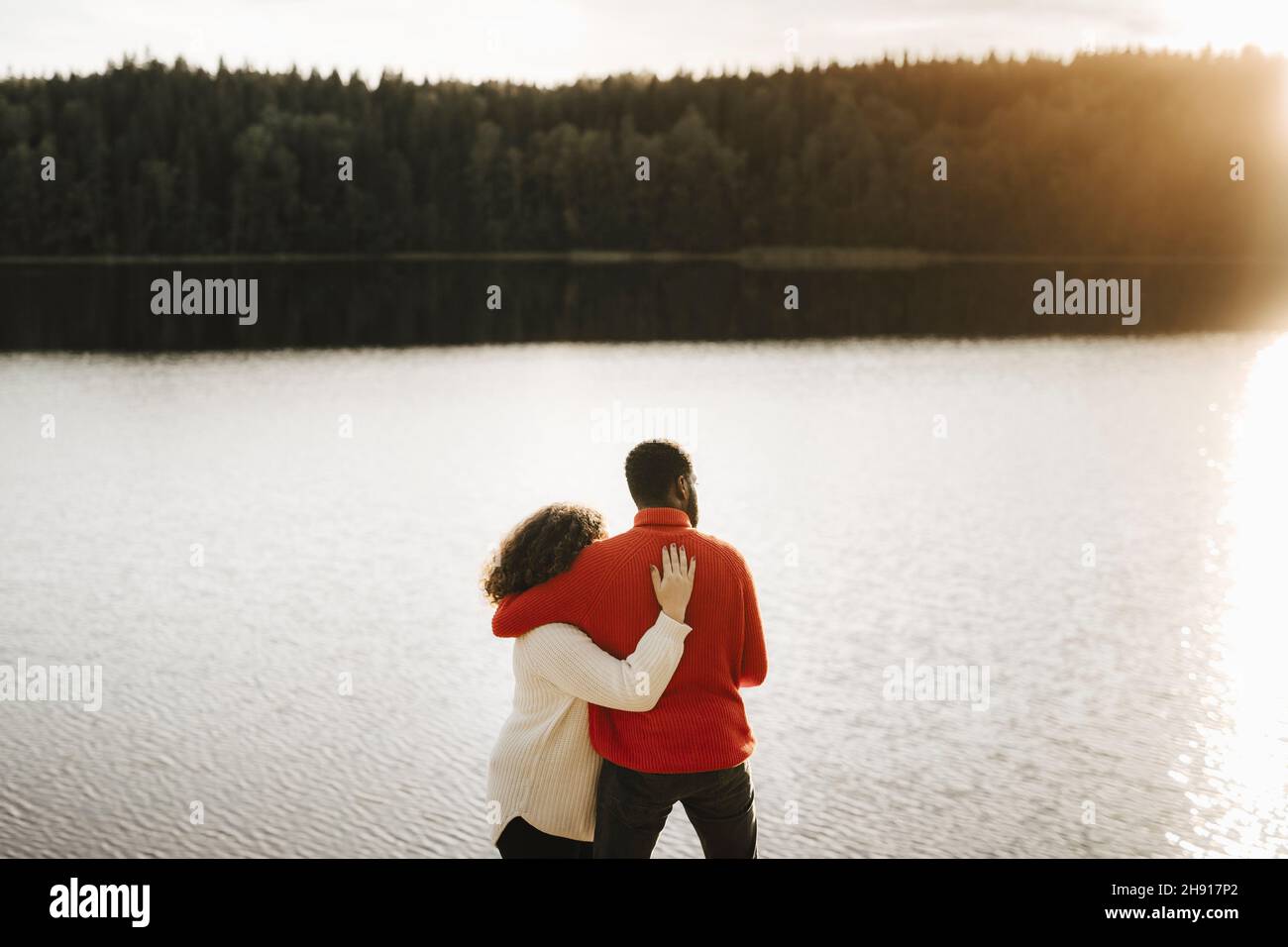 Coppia abbracciante mentre si guarda il lago Foto Stock