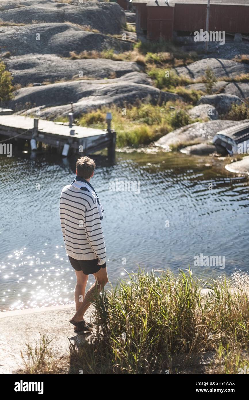 Uomo medio adulto che cammina lungo il fiume in giornata di sole Foto Stock