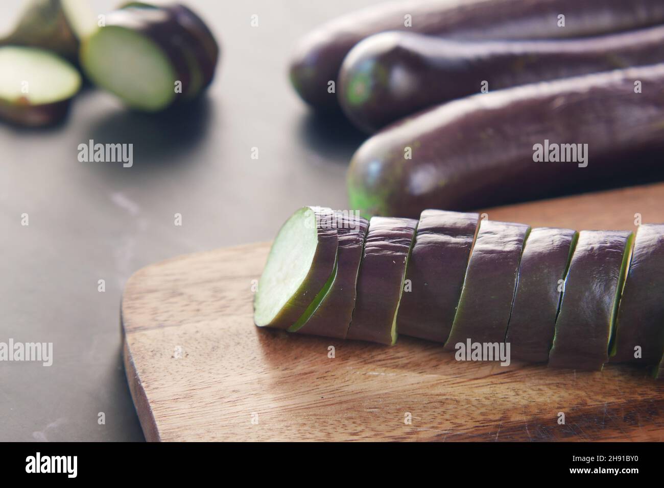 tagliando melanzane su un tagliere Foto Stock