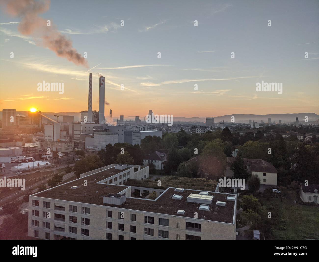 Una fabbrica a Basilea si distingue contro la città in questa foto scattata in una chiara mattinata di settembre. Foto Stock