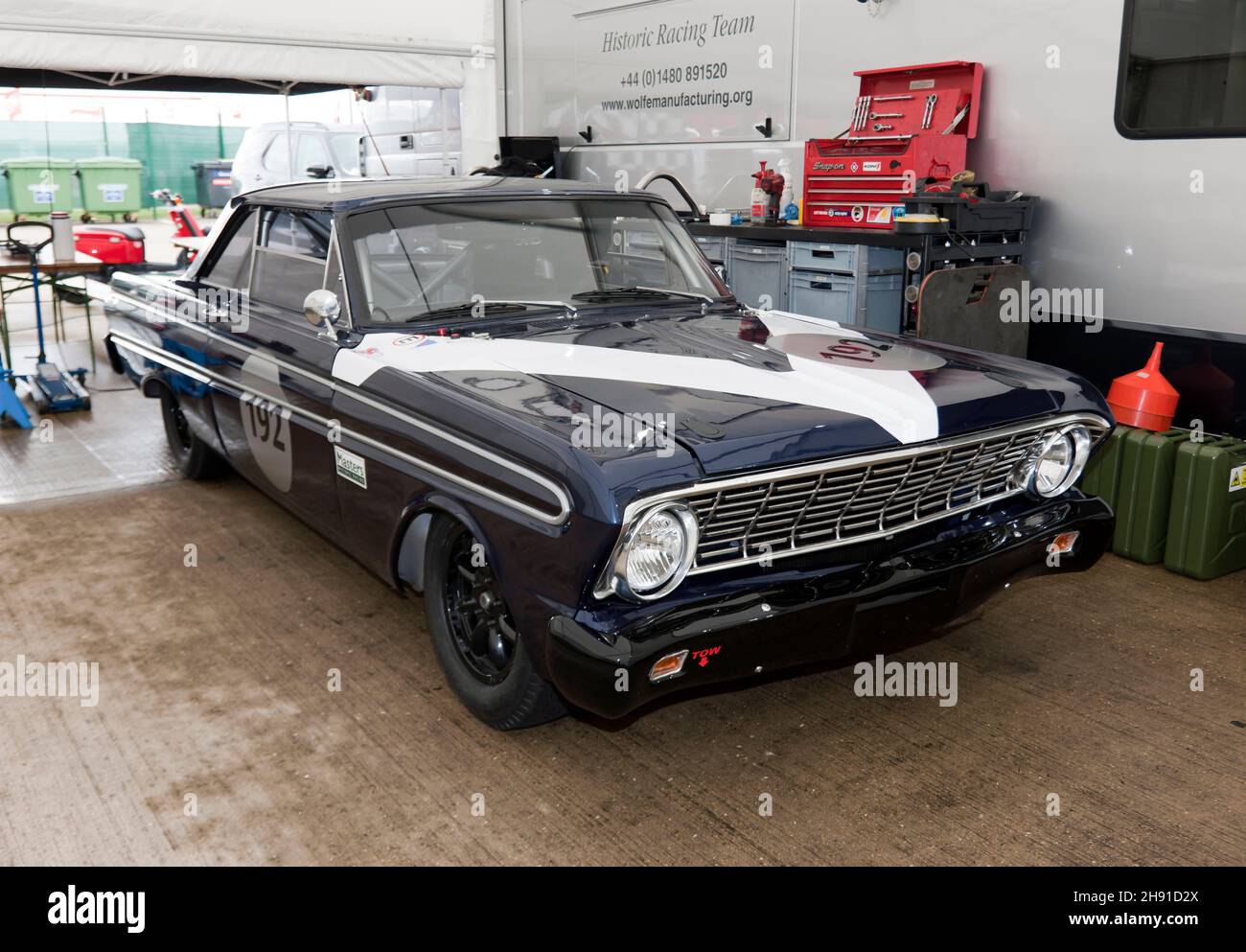 Vista frontale di tre quarti di un Dark Blue, 1964 Ford Falcon, nel box garage dello storico Racing Team, al Silverstone Classic 2021 Foto Stock