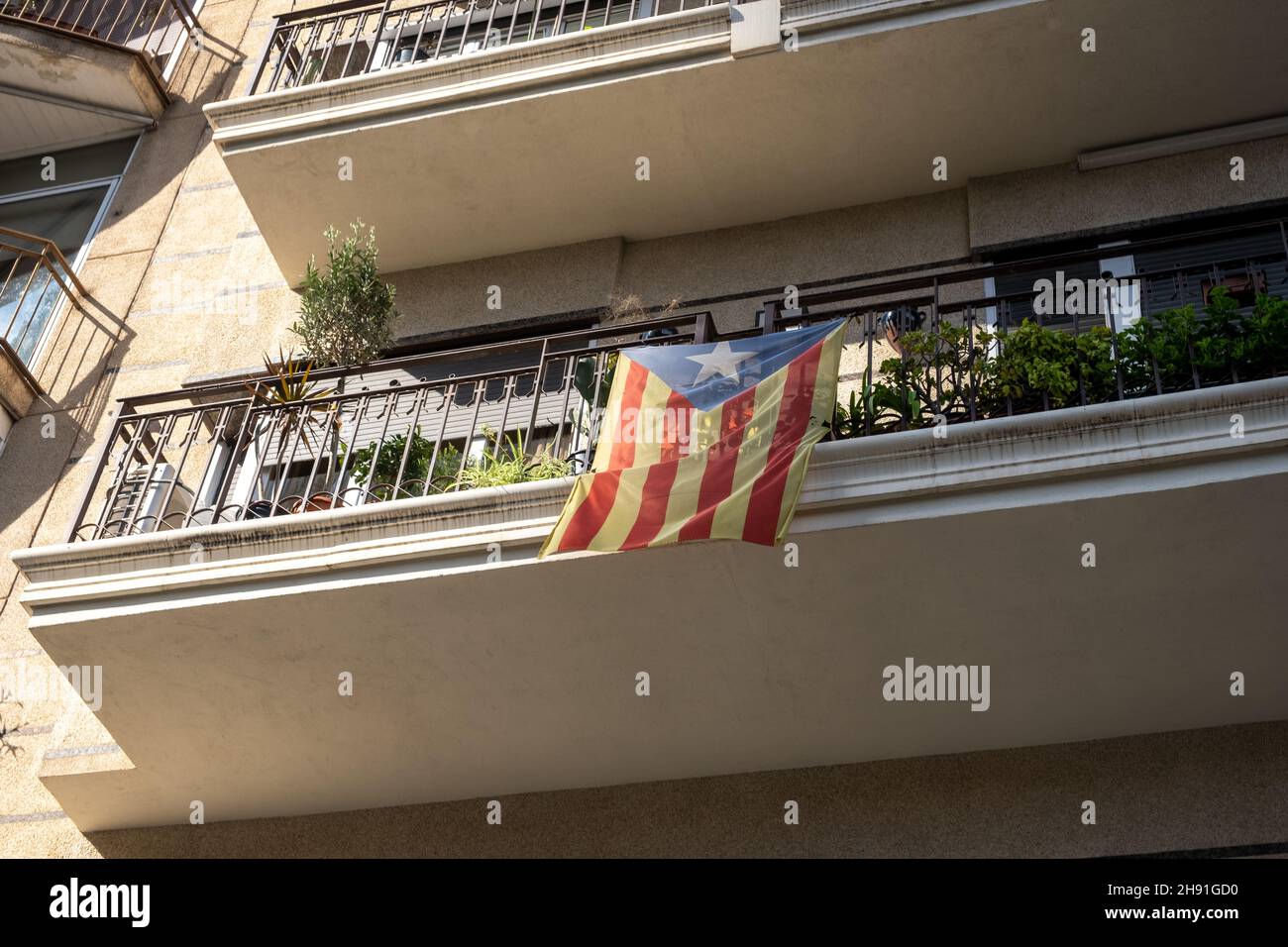 Bandiera della Catalogna sulla strada dell'edificio. Segno nazionale di indipendenza della Catalogna. Foto Stock