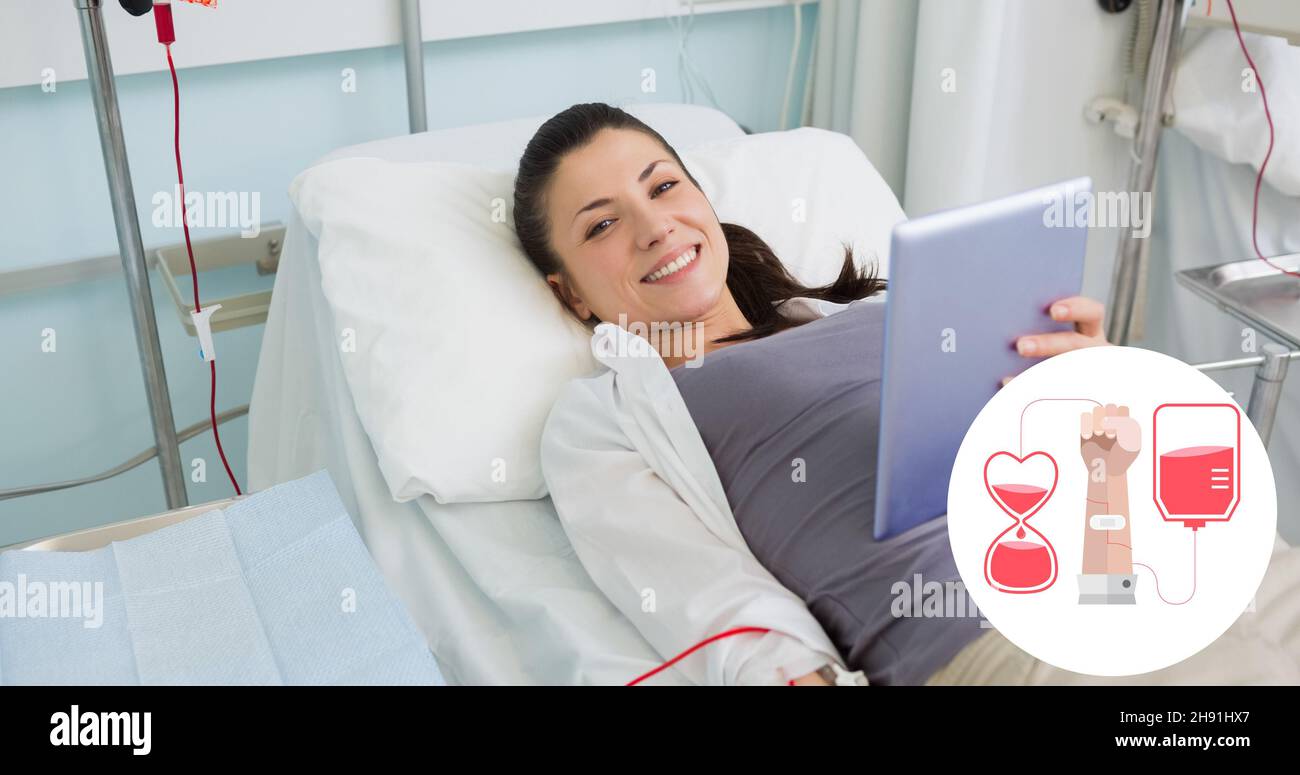 Ritratto di donna sorridente donatore sdraiato con tavoletta digitale a letto durante la donazione di sangue in ospedale Foto Stock