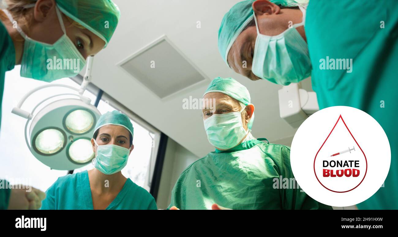 Composito digitale di donare il simbolo del sangue sul team chirurgo in pronto soccorso in ospedale Foto Stock