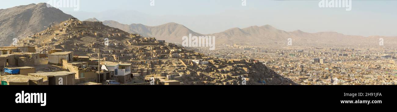 Una vista panoramica di Kabul con i suoi molti insediamenti informali sulle colline con case costruite di fango che forniscono rifugio ad una grande popolazione di disp Foto Stock