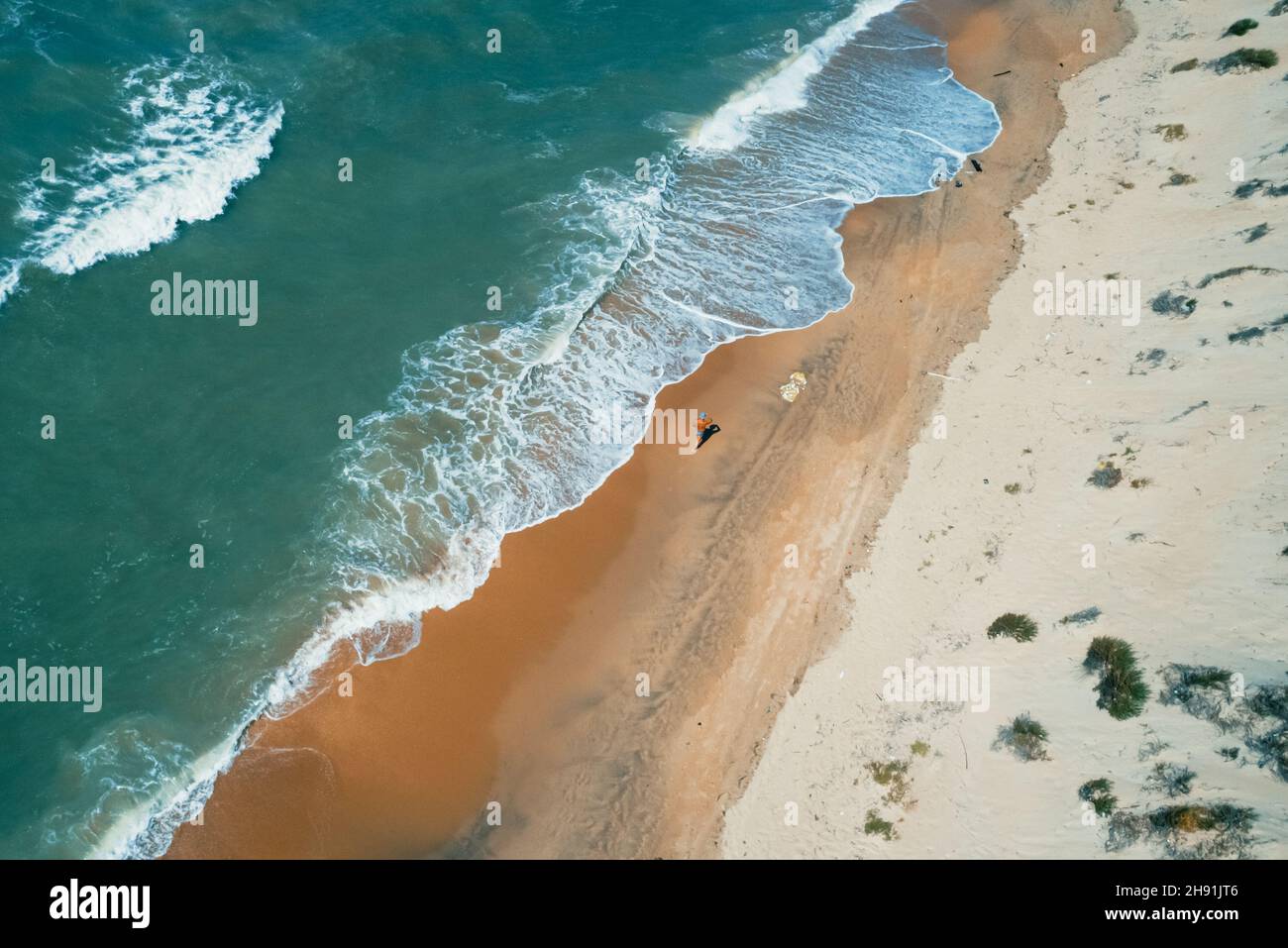 Scatto aereo di spiaggia e onde in crash. Bellissima spiaggia di sabbia e acque turchesi del mare tropicale. Perfetta stagione estiva. Foto Stock