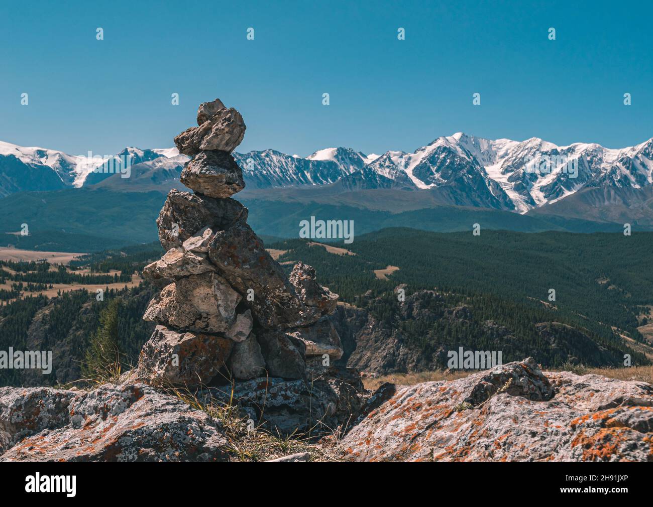 Cairn di pietra e montagne innevate sullo sfondo. Bellissimo paesaggio della regione di Altay, Russia. Foto Stock