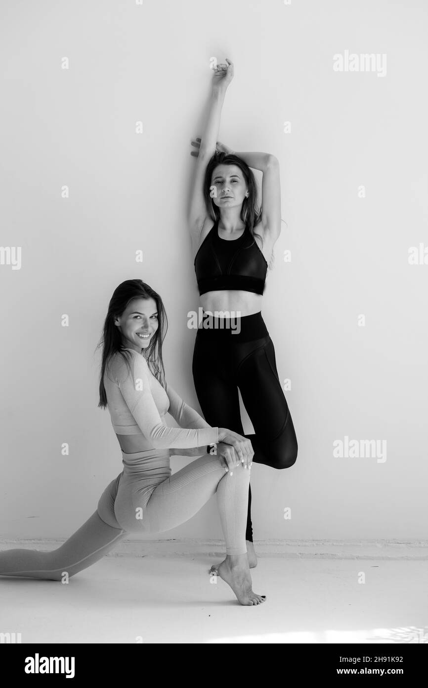 Due ragazze sportive che posano isolate su uno sfondo bianco. Modello di fitness donna in studio con spazio di copia Foto Stock