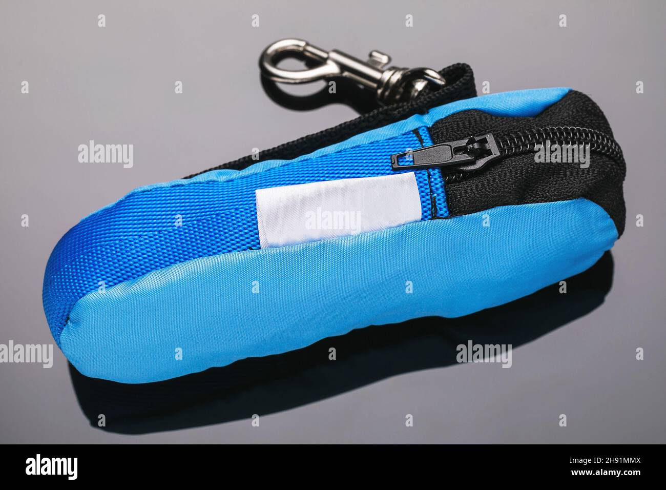 Una piccola borsa in tessuto blu con illuminazione per la tastiera su sfondo graduato Foto Stock