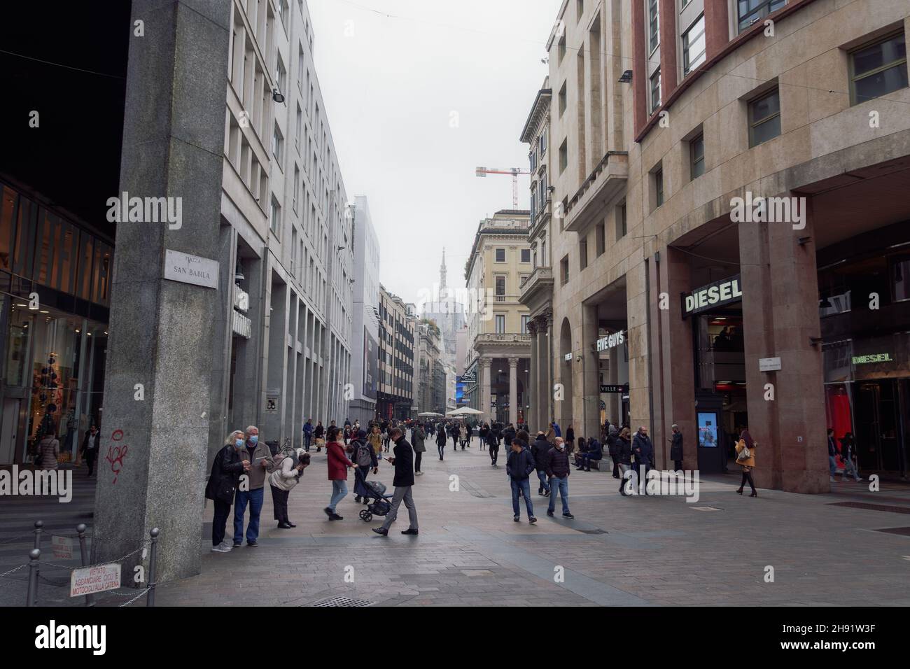 Milano, Italia persone con le maschere covid-19 nel centro della città. Folla con coronavirus protezione del viso passeggiate nella zona pedonale di piazza San Babila. Foto Stock
