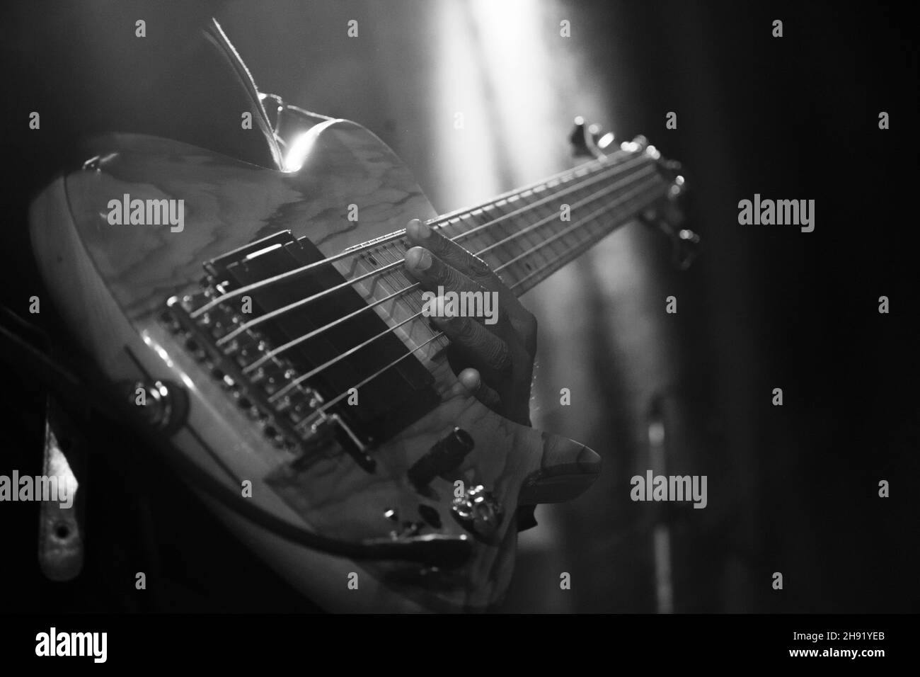 Scatto in scala di grigi di un musicista che suona sulla chitarra elettrica Foto Stock