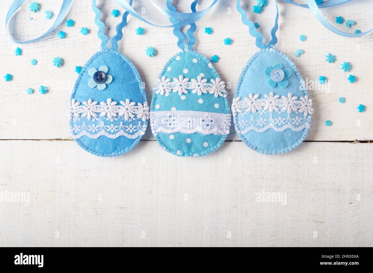 Mosaico artigianale feltro blu le uova di pasqua su bianco tavolo in legno Foto Stock