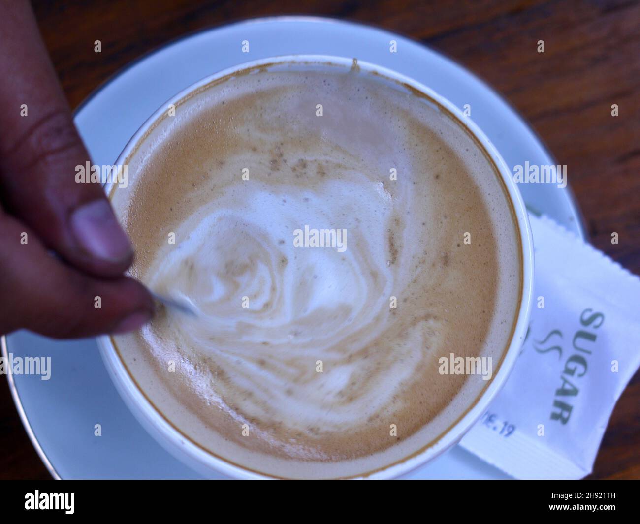 una tazza di latte di caffè che viene agitata Foto Stock