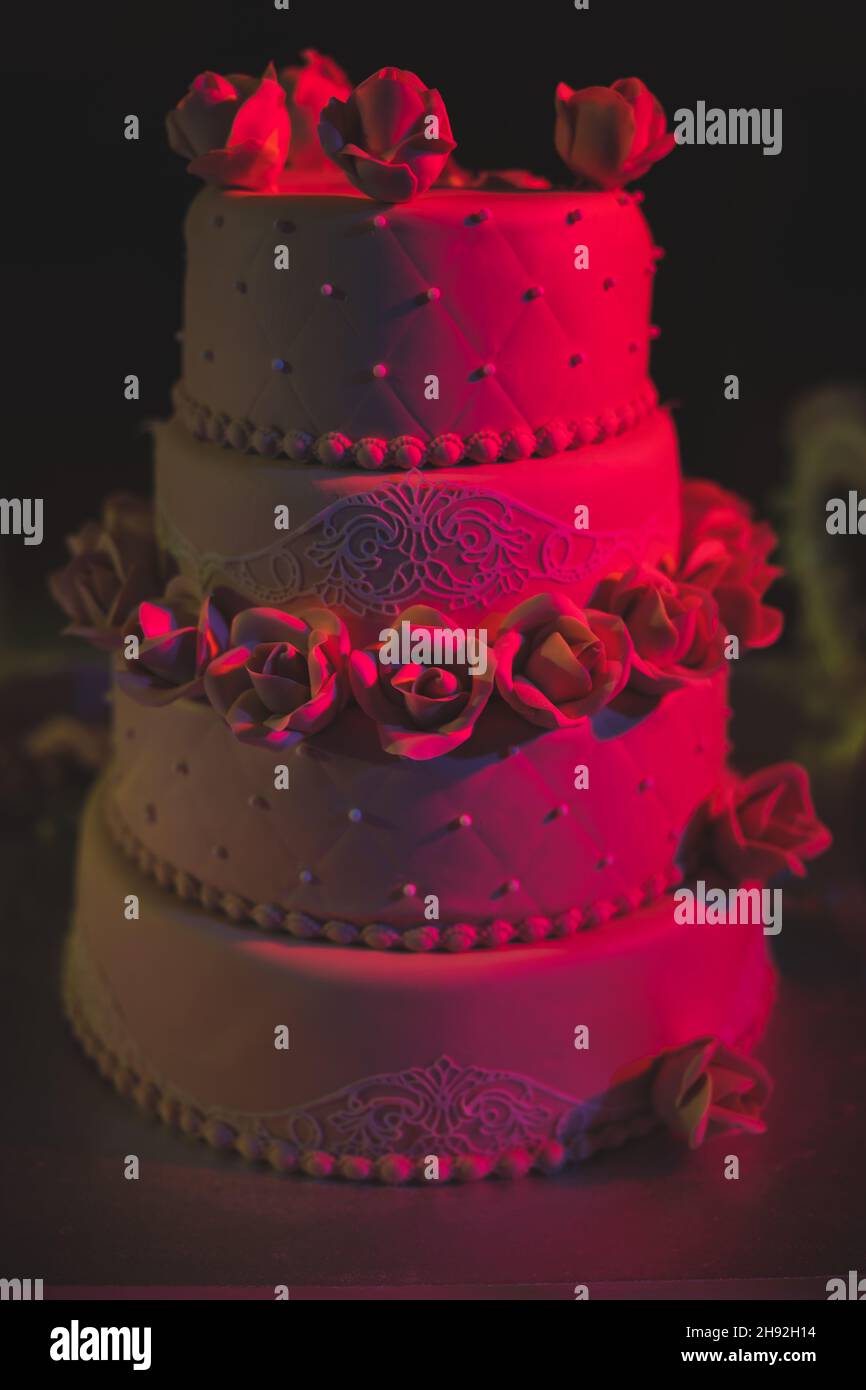 Una bella torta di nozze a tre livelli marrone con rose. Torta di festa dall'aspetto gustoso. Foto di alta qualità Foto Stock