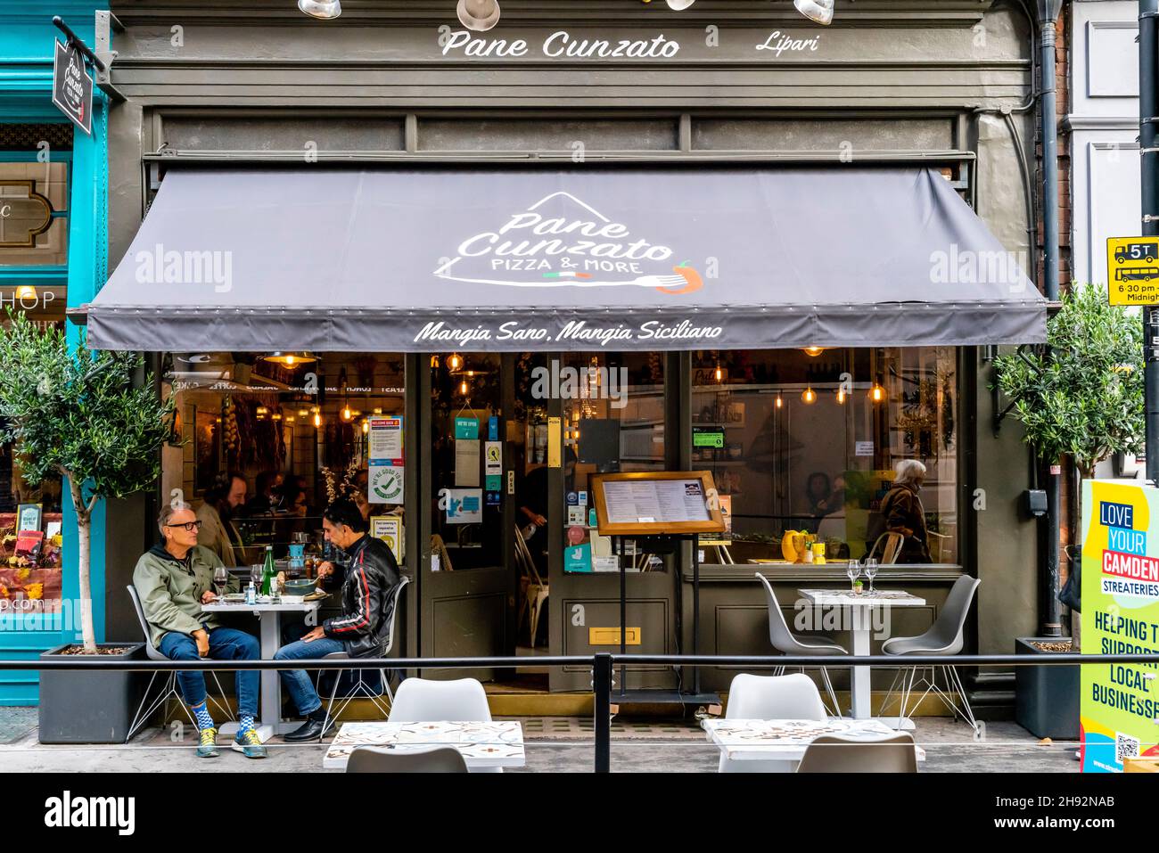 Clienti seduti all'esterno del ristorante siciliano pane Cunzato, Musuem Street, Londra, Regno Unito. Foto Stock