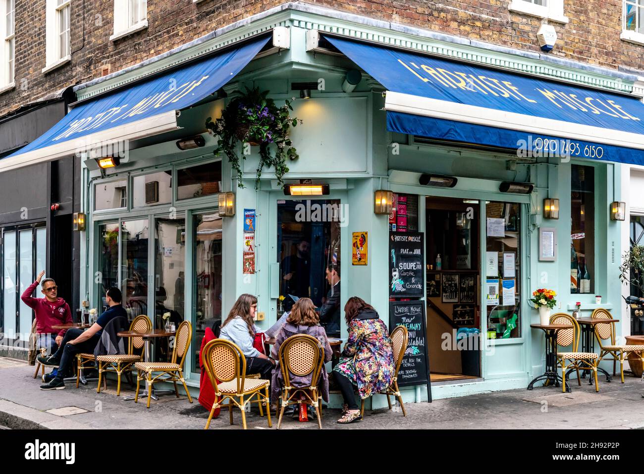 Le persone che siedono fuori dal ristorante l’Artiste Muscle pranzano, Shepherd Market, Londra, Regno Unito. Foto Stock
