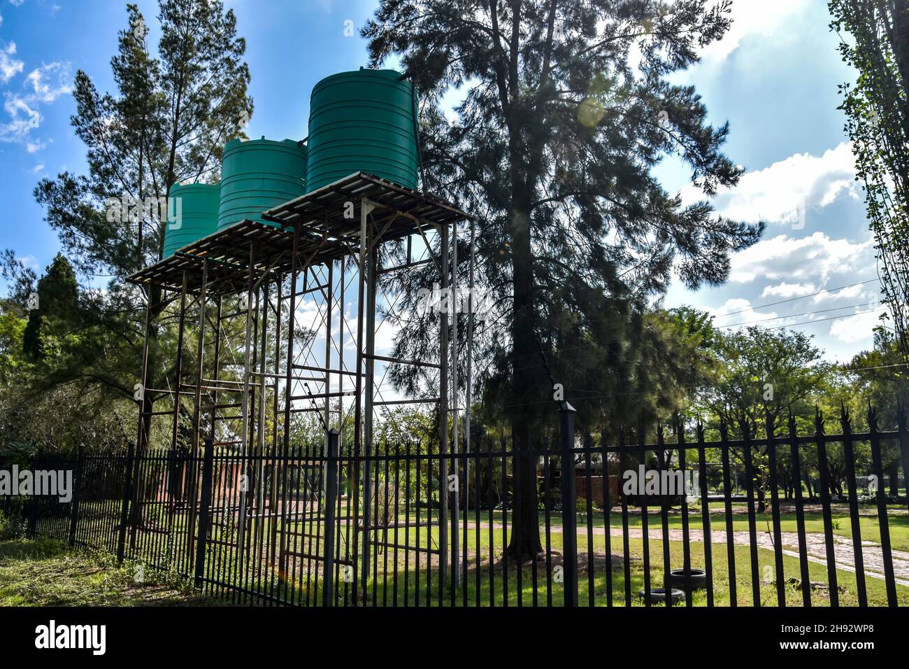 Serbatoi o contenitori di acqua in plastica verde su una struttura o torre di metallo sopraelevata per la pressione comunemente utilizzati in Africa meridionale per la stor d'acqua domestica Foto Stock