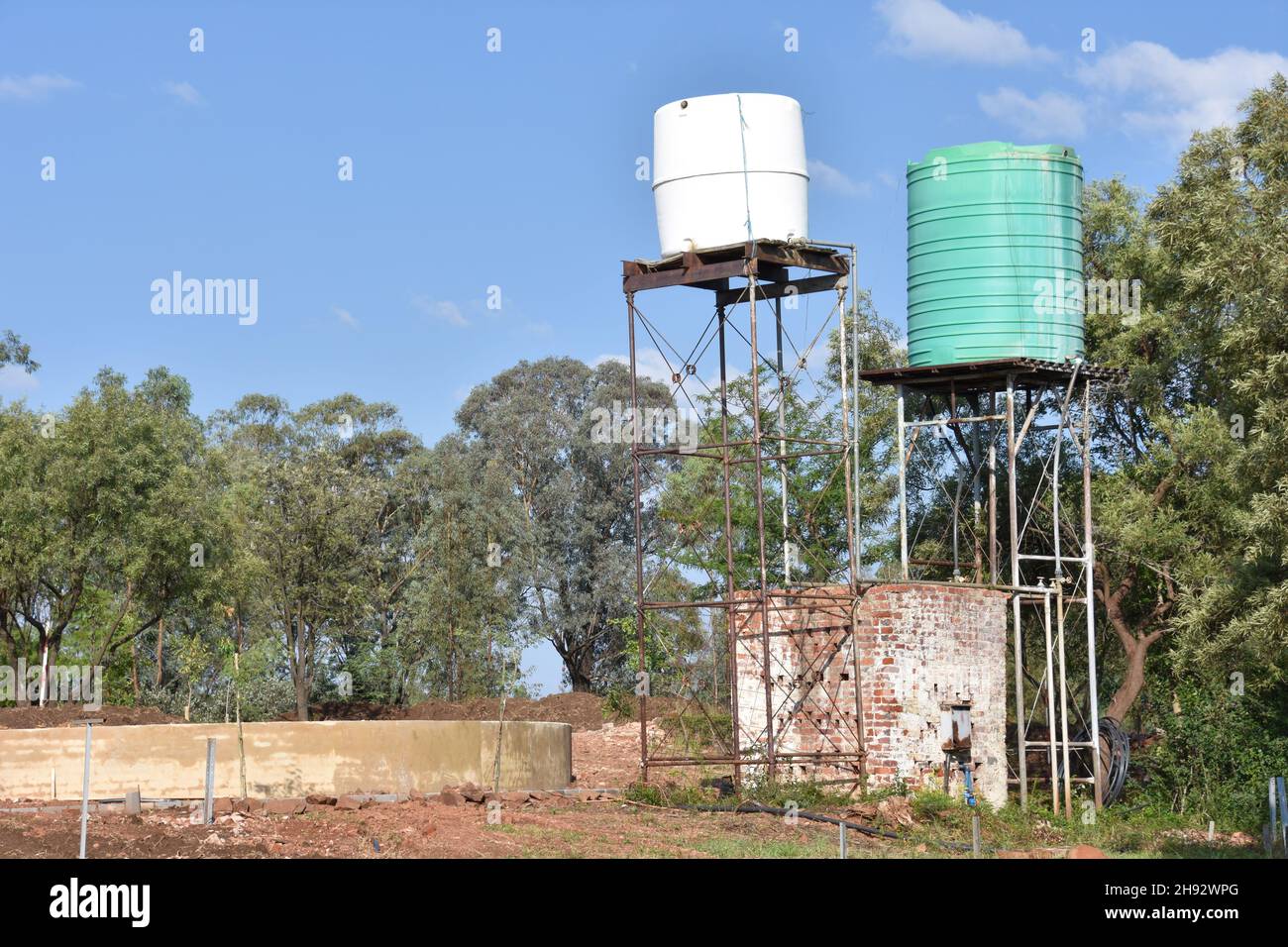 Serbatoi o contenitori in plastica verde e bianco su una struttura o torre in metallo sopraelevata per la pressione comunemente utilizzati in Africa meridionale per la casa Foto Stock