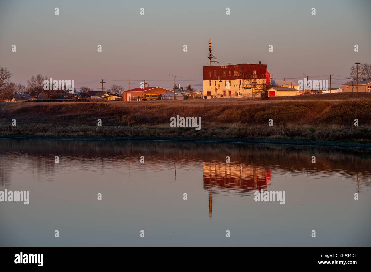 Hanna, Alberta - 23 ottobre 2021: Vecchio hotel abbandonato riflesso in un lago nella città di Hanna. Foto Stock