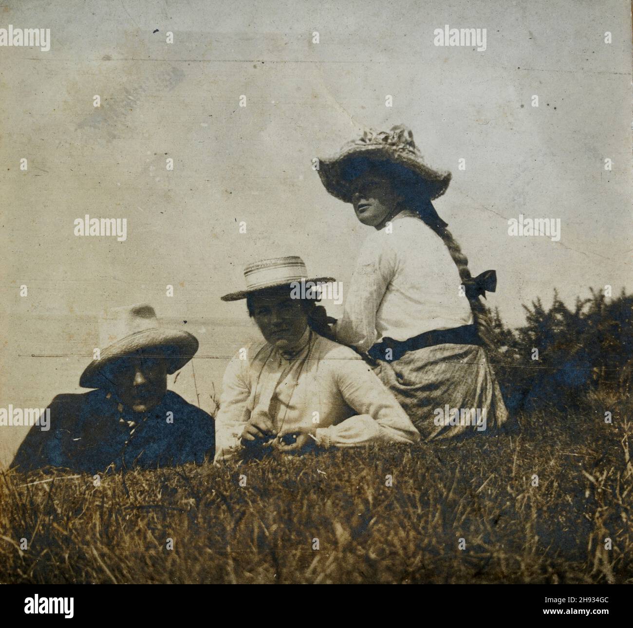 Foto d'epoca di Padre e figlie deposte sull'erba, giorno d'estate in stile edoardiano, inglese, anonimo, anni '10 Foto Stock