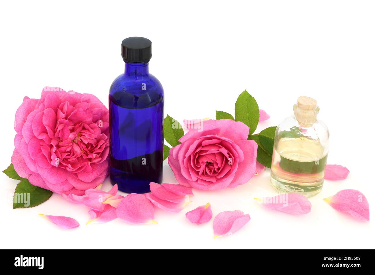 Acqua di rosa in bottiglia con fiori rosa e petali con olio di mandorle. Utilizzato per l'idratazione della pelle, aiuta a mantenere l'equilibrio del ph della pelle, è antibatterico Foto Stock