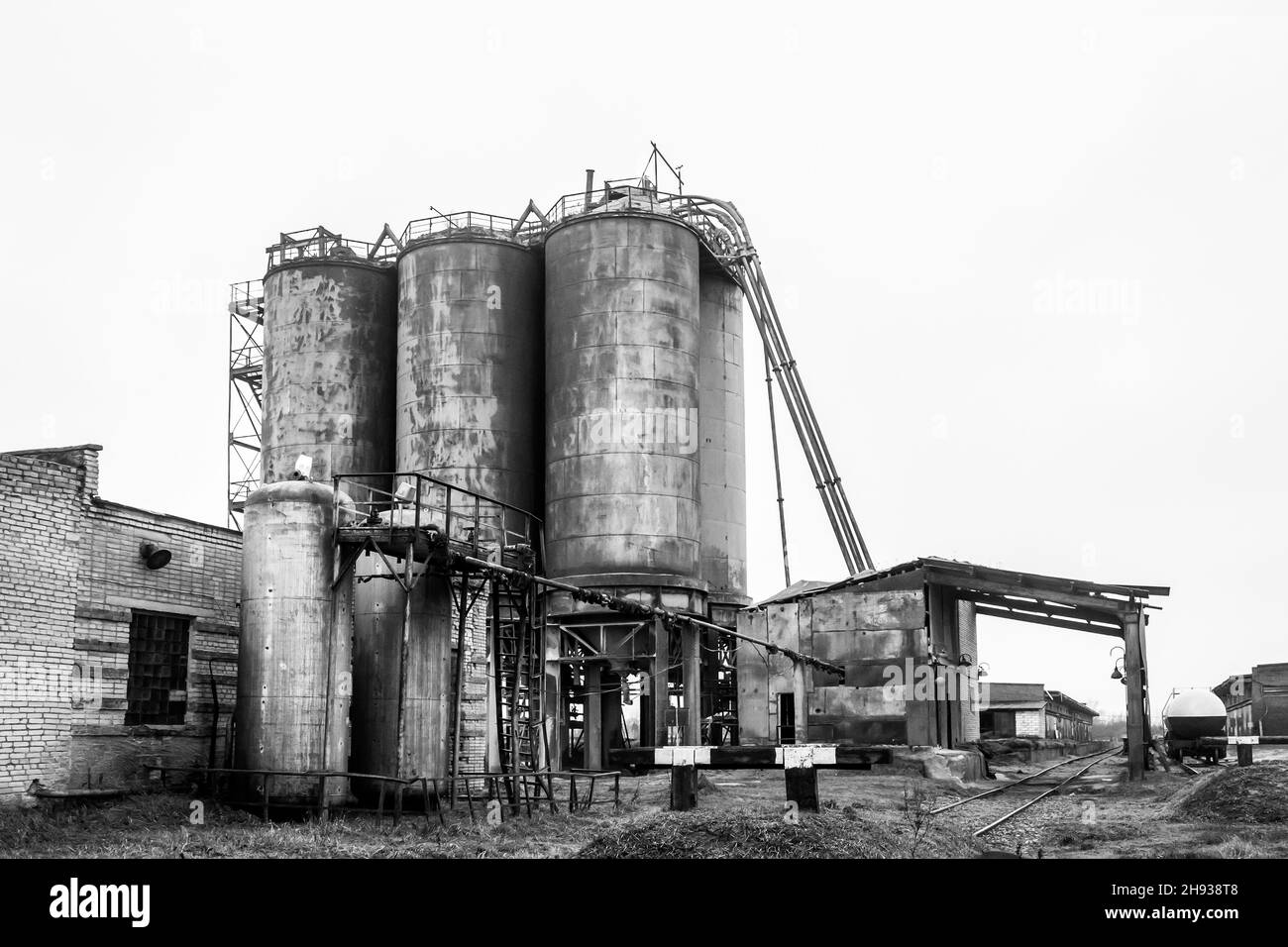 Alimentare l'olio del serbatoio chimico vecchio in un impianto industriale abbandonato. Foto Stock