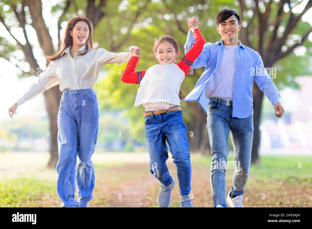 Happy Family saltando e giocando insieme nel parco Foto Stock