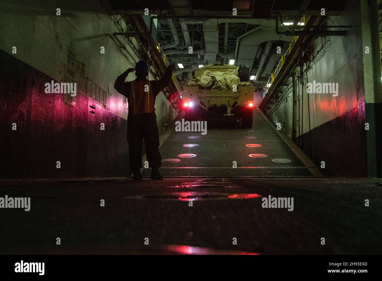 US Marine PFC. Keven Montez, Combat CARGO con la 22a unità Marine Expeditionary, guida un veicolo attraverso il ponte pozzo a bordo, nave d'assalto anfibio USS Kearsarge (LHD 3), 1 dicembre 2021. Kearsarge, l'ammiraglia per la ventiduesima unità di spedizione marina (MEU) e lo squadrone anfibio (PHIBRON) Six, è in corso per l'esercizio AMX (Amphibious Ready Group/MEU Exercise) in preparazione di un futuro impiego. AMX è il secondo periodo in mare del programma di formazione per la predistribuzione della MEU; mira a testare le capacità del team ARG/MEU in un ambiente di minaccia realistico. (STATI UNITI Foto del corpo marino di Cp Foto Stock