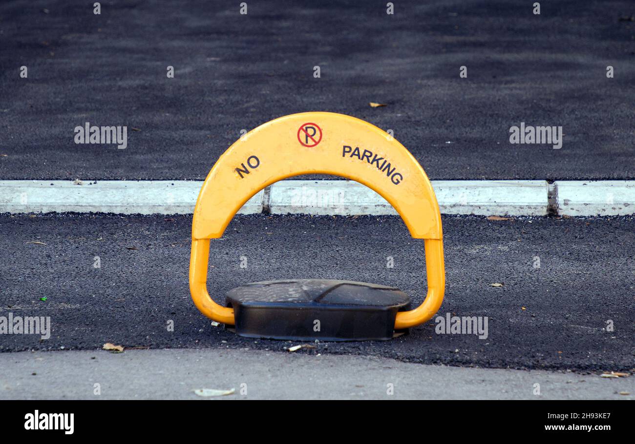 Barriera di parcheggio con telecomando sul marciapiede della strada della città Foto Stock