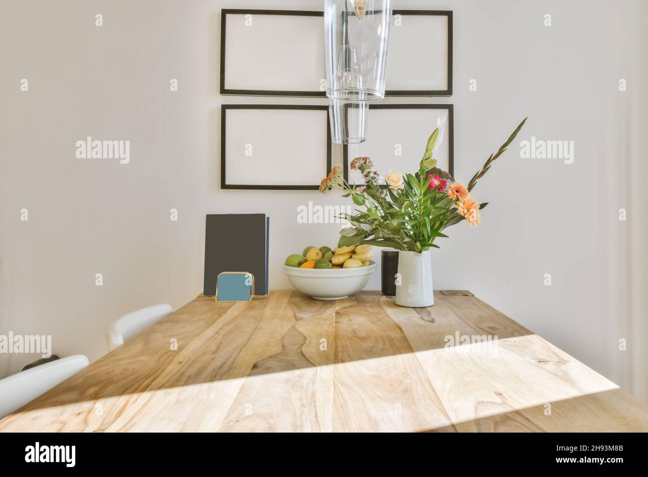 Lussuoso tavolo in legno con una ciotola di frutta e un vaso di fiori Foto Stock
