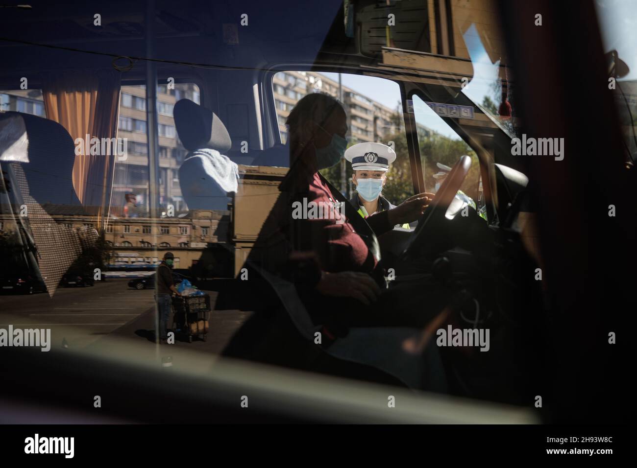 Bucarest, Romania - 18 ottobre 2020: L'ufficiale di polizia femminile tira sopra le automobili nel traffico per controllare se i conducenti rispettano le misure anticovidio. Foto Stock