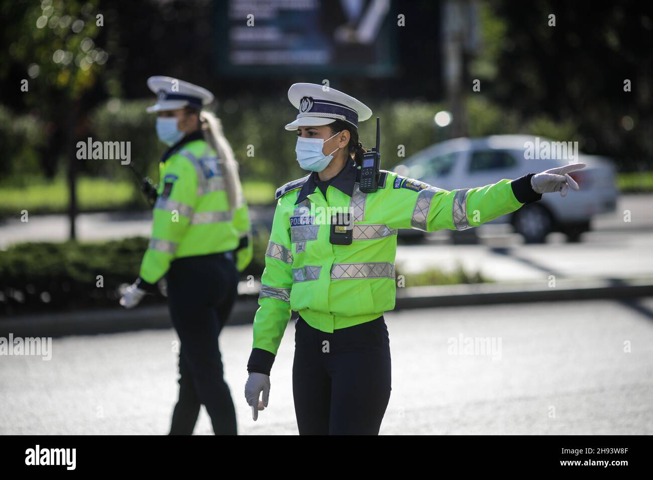 Bucarest, Romania - 18 ottobre 2020: L'ufficiale di polizia femminile tira sopra le automobili nel traffico per controllare se i conducenti rispettano le misure anticovidio. Foto Stock