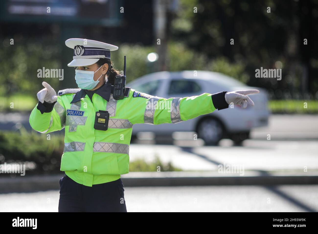 Bucarest, Romania - 18 ottobre 2020: L'ufficiale di polizia femminile tira sopra le automobili nel traffico per controllare se i conducenti rispettano le misure anticovidio. Foto Stock