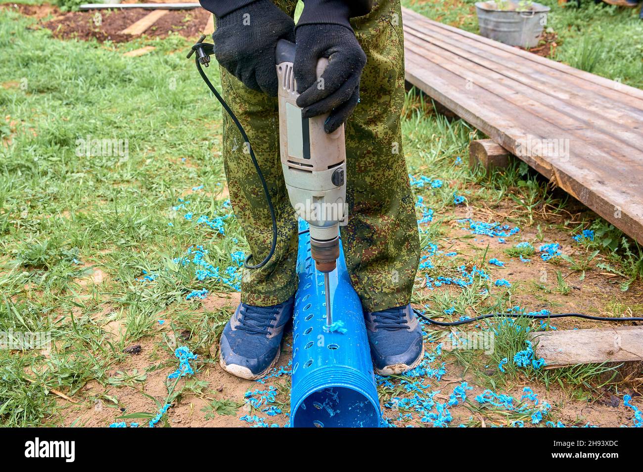 praticare dei fori in un tubo di plastica Foto Stock