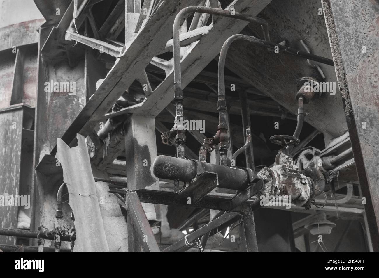 Vecchio sistema di tubazioni e unità di distribuzione con tubi per impianto industriale barile chimico liquido. Foto Stock